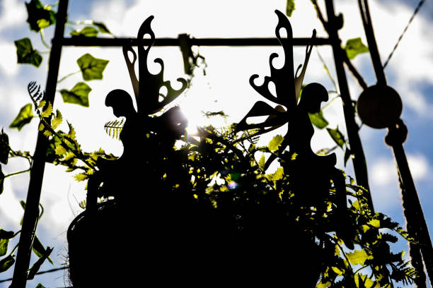 white decorative fairies in a beautiful decorative vase with plants on a terrace, backlit