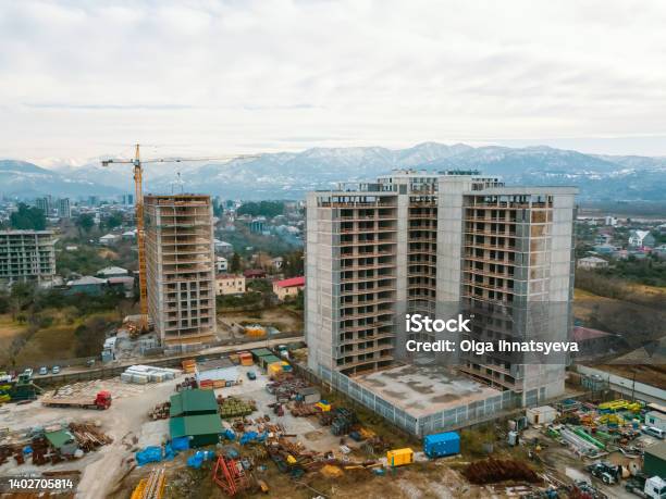 Drone View Of The Construction Site Multistorey Buildings Under Construction Against The Background Of Mountains Construction Machinery Excavators Tractor Crane Stock Photo - Download Image Now