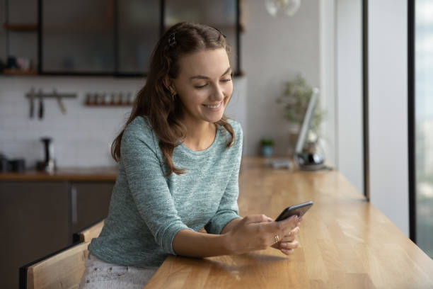istock Smiling Caucasian woman use cellphone texting online 1402711481