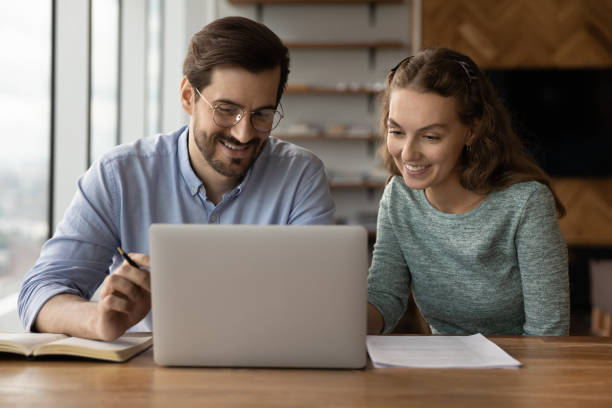 istock Smiling diverse colleagues brainstorm on computer in office 1402711523