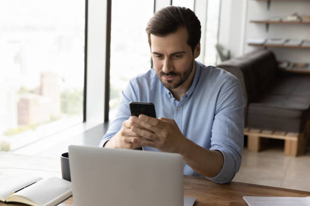 istock Serious male employee use gadgets at workplace 1402711559