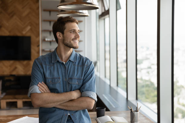 istock Smiling male employee look in distance making plans 1402711570