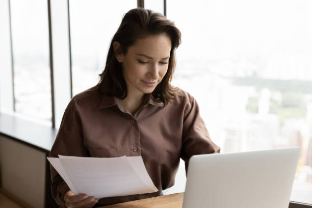 istock Caucasian female employee work with paperwork on computer 1402711987