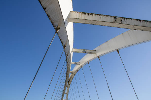 antike metallbrücke aus weissem stahl bei ebbe an einem sonnigen sommertag - twisted bridge surreal stock-fotos und bilder