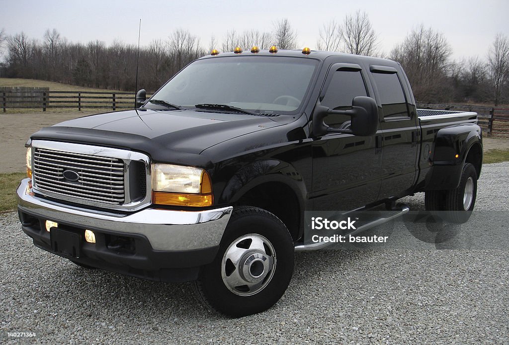 Dually Truck Big black dual rear wheel diesel truck with lights on at dusk. Pick-up Truck Stock Photo