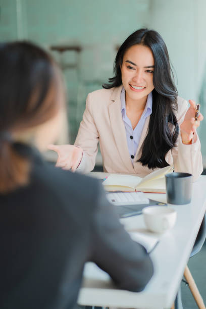 istock Two Asian business women working together using digital tablets discussing new startup project ideas. Analyze the planning and statistics of the financial and investment markets at the office. 1402715681