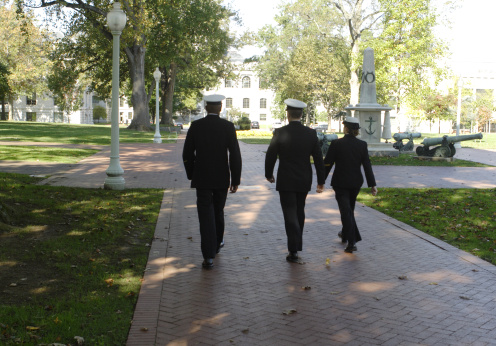 Three cadets at the Naval Acadamy in Annapolis, Maryland walking accross campus