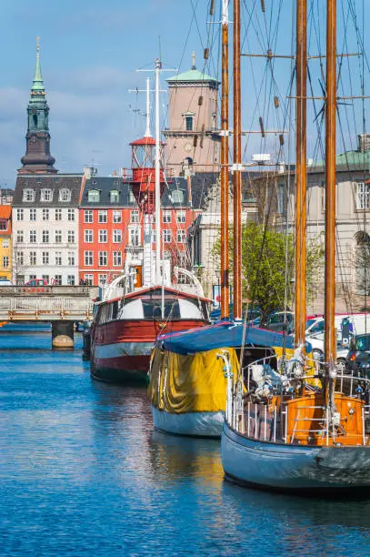 Colourful villas, towers and spires of central Copenhagen overlooking yachts moored in the harbour, Denmark.