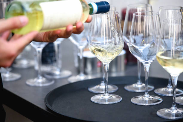 istock Bartender pouring wine into wineglasses 1402727390