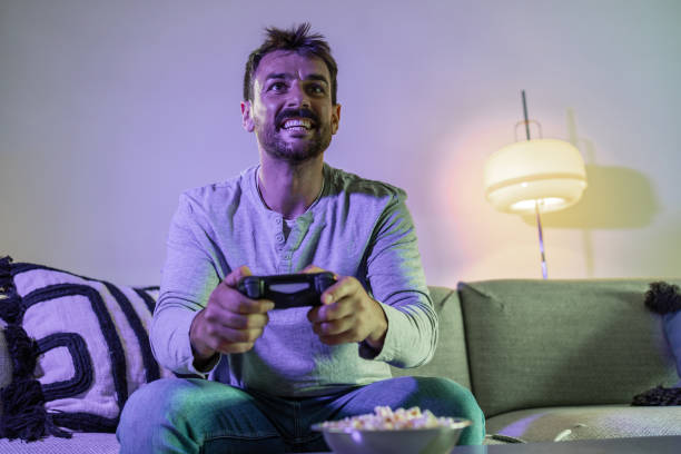 istock Happy man playing  video games at home 1402728799