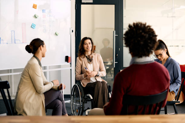 happy disabled businesswoman brainstorming with her coworkers during presentation in meeting room. - ceo corporate business indoors lifestyles imagens e fotografias de stock