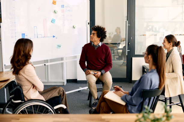 istock Black businessman explaining his coworkers business strategy on whiteboard during presentation in meting room. 1402731568