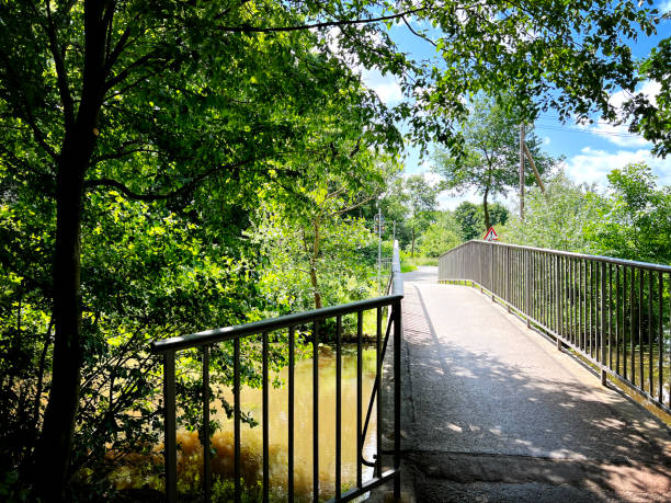 istock A bicycle and pedestrian bridge over a small dirty river. 1402731751