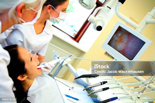 Dentists Assisting A Female Patient Stock Photo - Download Image Now - Removing, Adult, Adults Only