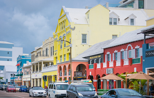 Hamilton, Bermuda May 24, 2022- Rows of cars drive past the colorful shops and stores of many descriptions that cater to visitors and vacationers of this beautiful island.