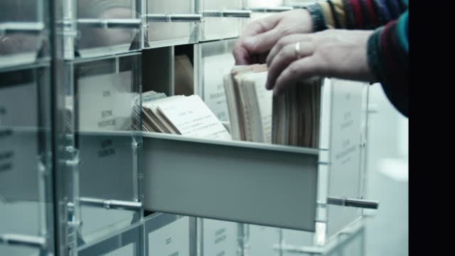 Looking through drawer full of files. Public library