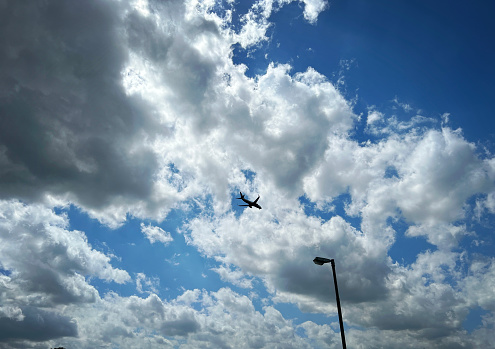 Beautiful cloudy sky with a landing plane.