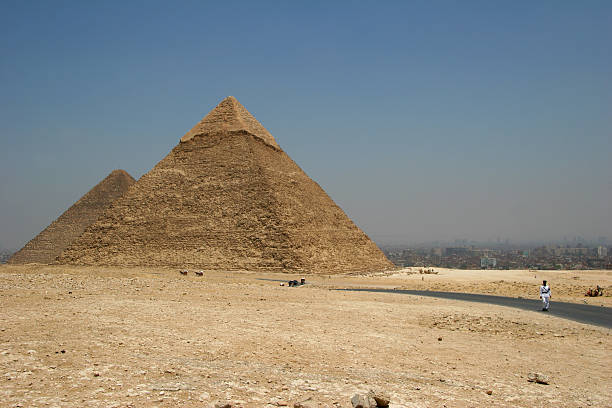 Two Gizeh pyramids with polluted Cairo in background stock photo