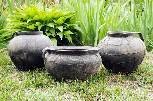 Three black vintage handmade clay pots with wire outdoor