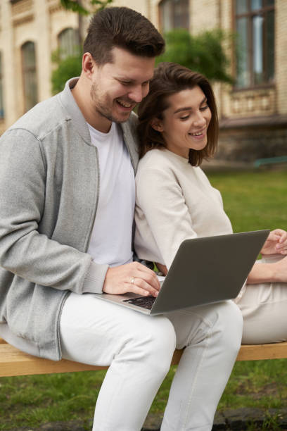 istock Happy couple using modern notebook on the street 1402735596