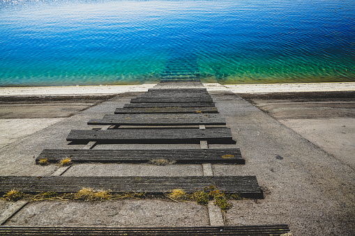 A wooden staircase to the blue water.
