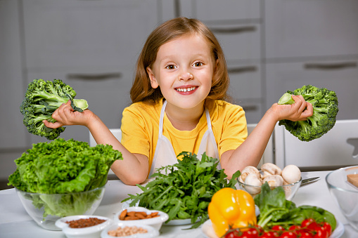 a blogger girl leads a stream about a healthy lifestyle and proper healthy nutrition. The girl plays with a heads of broccoli