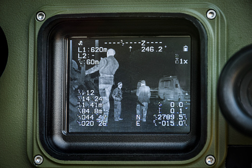 Image on the screen of a multi sensor military surveillance device. The opto-electronic device is equipped with a thermal camera, laser rangefinder and infrared sensor.