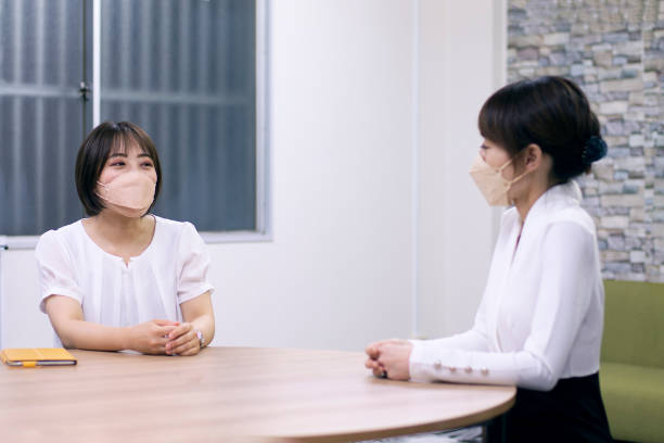 istock Two business women sitting at a same round table and talking together 1402739352