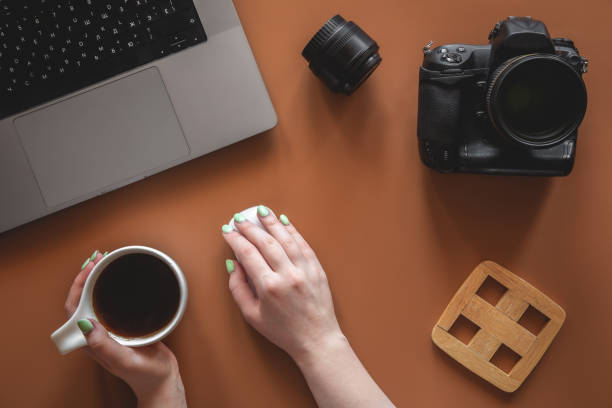 istock Photographer's workplace with camera and lens, flat lay. 1402739523