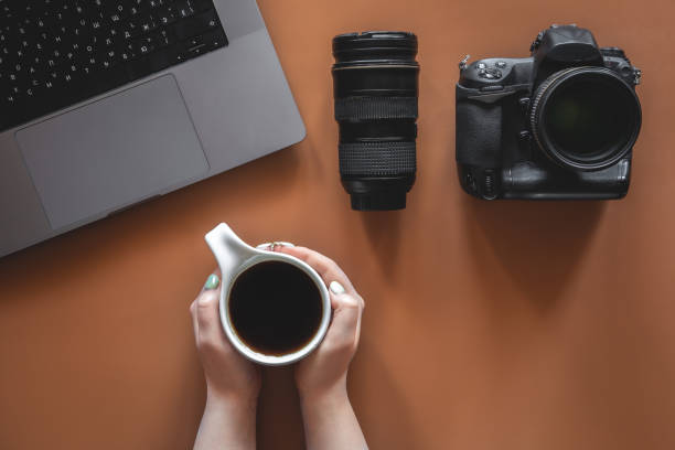istock Photographer's workplace with camera and lens, flat lay. 1402739525