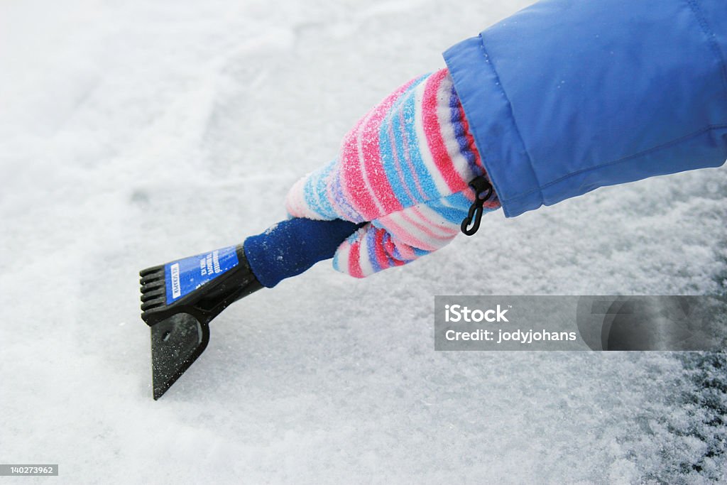 I Need A Garage Women scrapes the inch of ice from her windshield the morning after a winter storm Adult Stock Photo