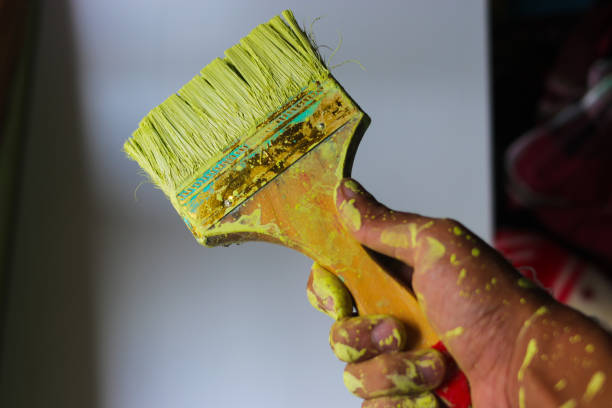 istock Hand with holding a dirty paintbrush with blurred background 1402739698