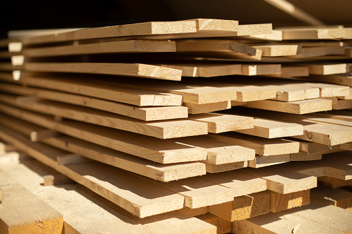 Boards in stock. White boards lie in stack. Building material in carpentry workshop.