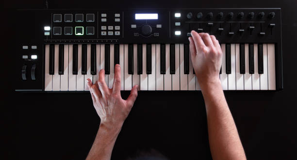 a male hands play on white musical keys on a black background. - piano piano key orchestra close up imagens e fotografias de stock