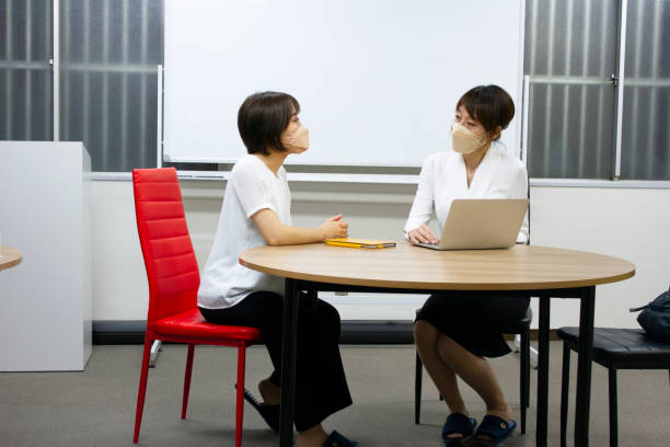 istock Two business women talking face to face at a round table 1402742312