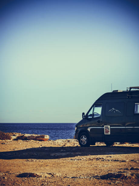 istock Camper van on sea cliff, camping. 1402744057