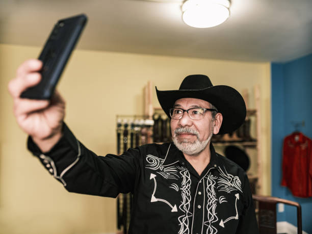 istock Mature Latin man dressed as Mexican Cowboy taking selfie 1402745031