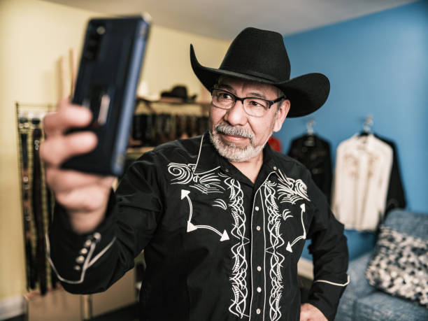 istock Mature Latin man dressed as Mexican Cowboy taking selfie 1402745063