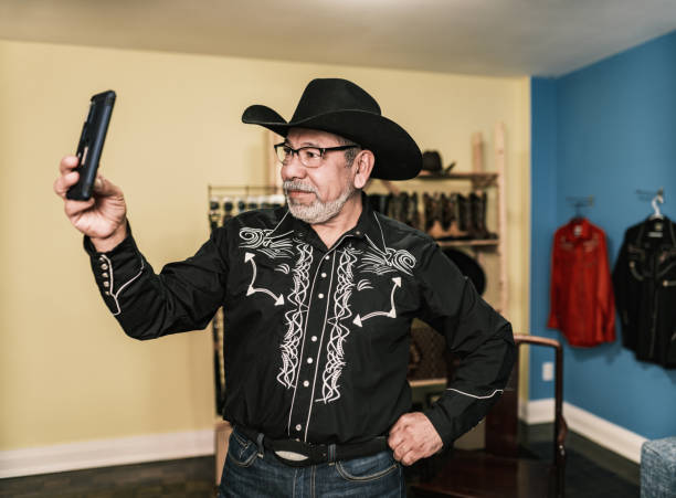 istock Mature Latin man dressed as Mexican Cowboy taking selfie 1402745064