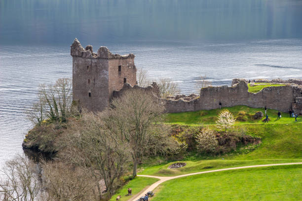 View of Urquhart Castle ruins along Loch Ness in Scotland Drumnadroichit, Scotland, United Kingdom - May 1, 2022: Landscape view of Urquhart Castle ruins (Caisteal na Sròine) along Loch Ness in the Highlands of Scotland. The castle dates back to the 13th Century, and was an important location in the Scottish independence wars of the 13th and 14th Centuries. drumnadrochit stock pictures, royalty-free photos & images