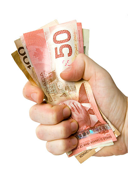 istock A hand holding some Canadian money 140275188