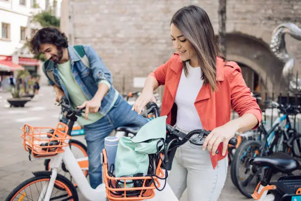 Young couple renting e-bikes to explore Barcelona.
