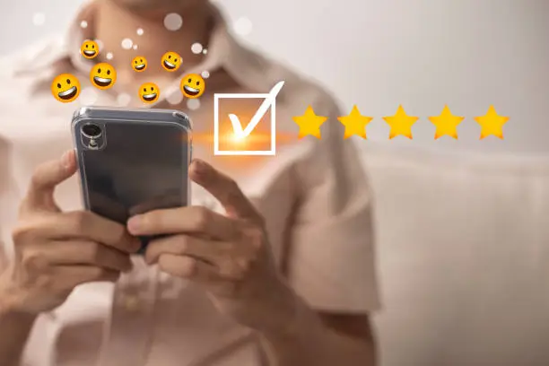 Photo of Satisfaction and customer service survey concept, business people using  smartphone. to answer the questionnaire And the satisfaction rating, the satisfaction rating with the smiley face icon 5 stars.