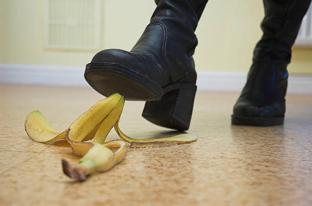 Banana skin lies ready to cause a painful slip-up. Slapstick concept illustrating danger and pitfalls.