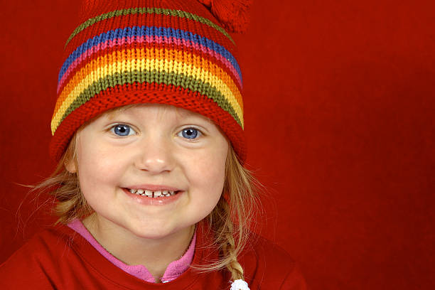 A cute little girl with a red hat smiling
