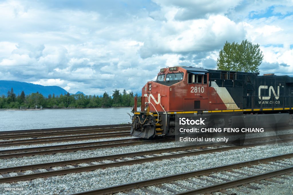 Canadian National Railway freight train traveling on rural area. British Columbia, Canada - April 30 2021 : Canadian National Railway freight train traveling on rural area. Train - Vehicle Stock Photo