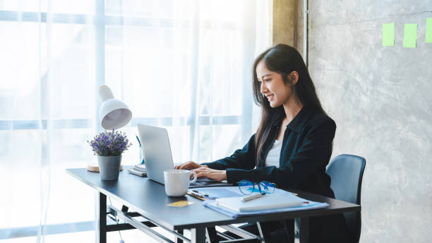 istock Young creative asian woman relaxing using technology of laptop computer while sitting on table. 1402763578