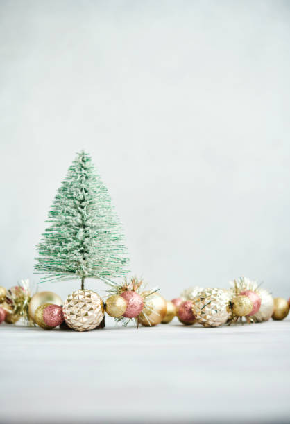 istock Christmas background with green tinsel tree and glittery gold Christmas decorations. Space for copy 1402766201