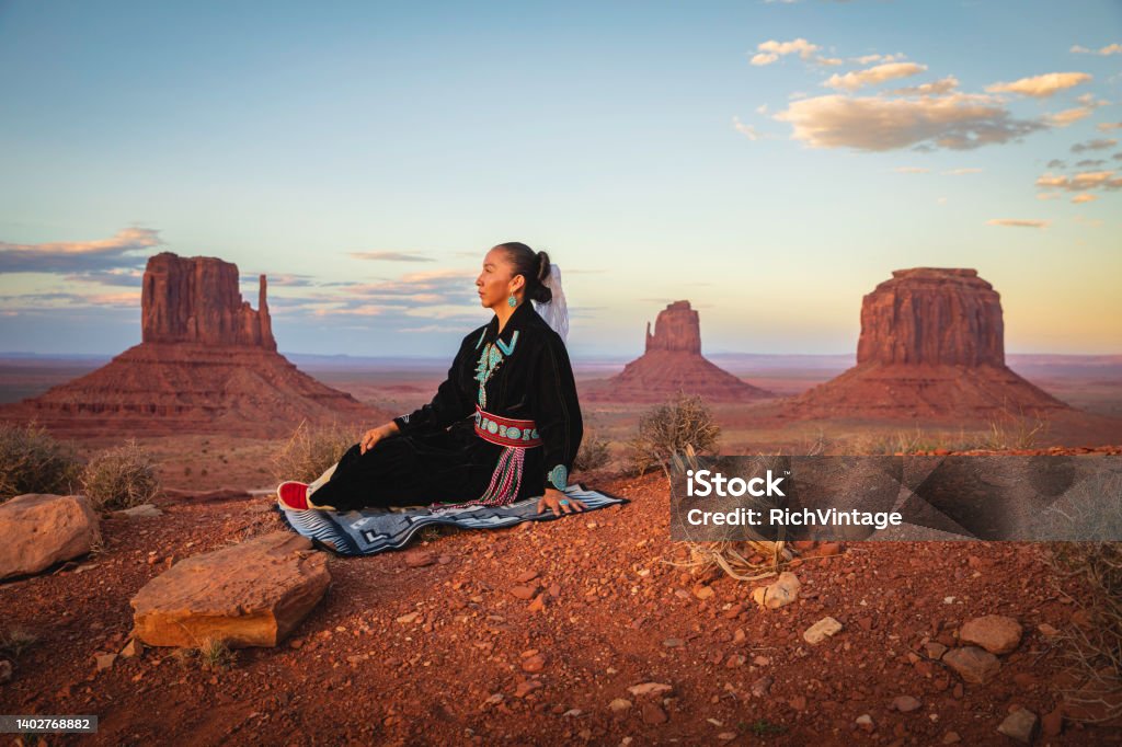 Native American Woman Portrait A Native American woman dressed in traditional Navajo clothing, poses in the landscape of Monument Valley, on the border of Utah and Arizona. Indigenous Peoples of the Americas Stock Photo