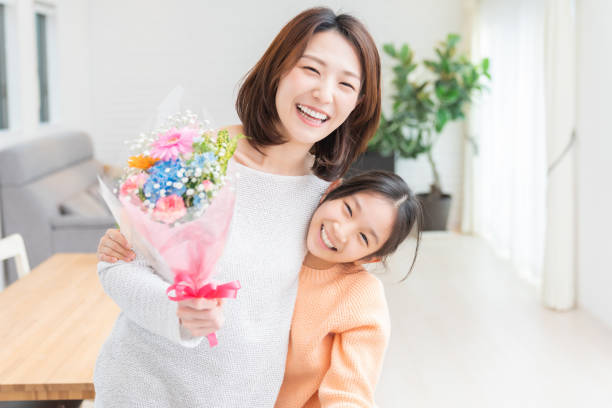mère et fille asiatiques, bouquet - gift mothers day birthday giving photos et images de collection
